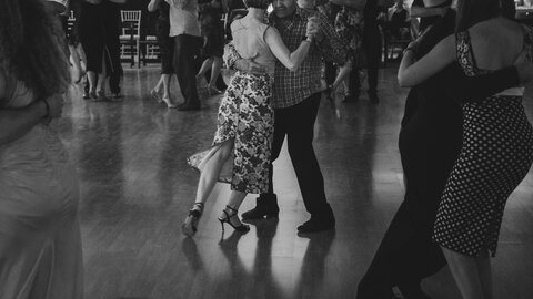 Des couples dansant dans une salle de bal faiblement eclairee